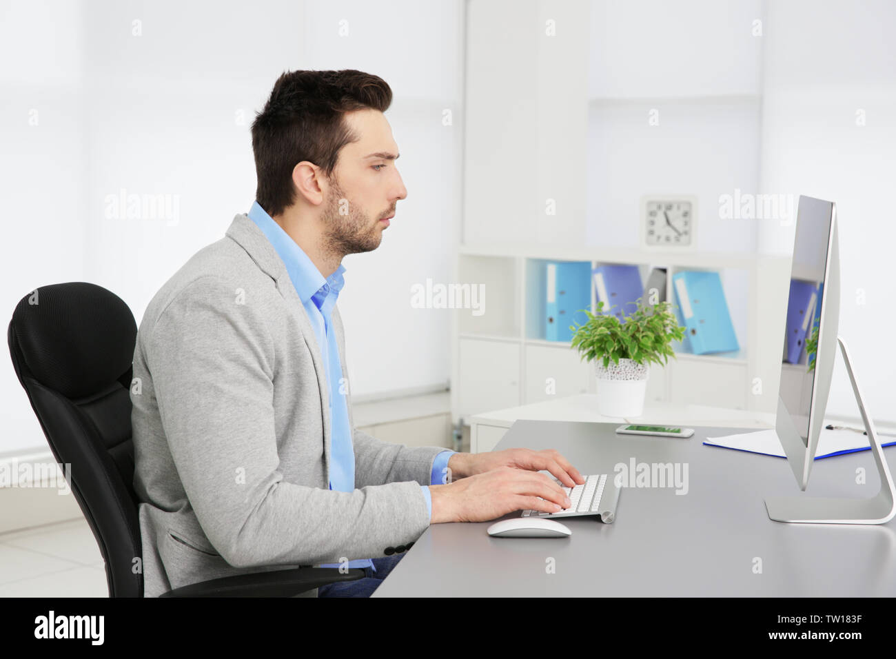 La possibilità di postura non corretta nozione. Uomo seduto al tavolo per ufficio Foto Stock