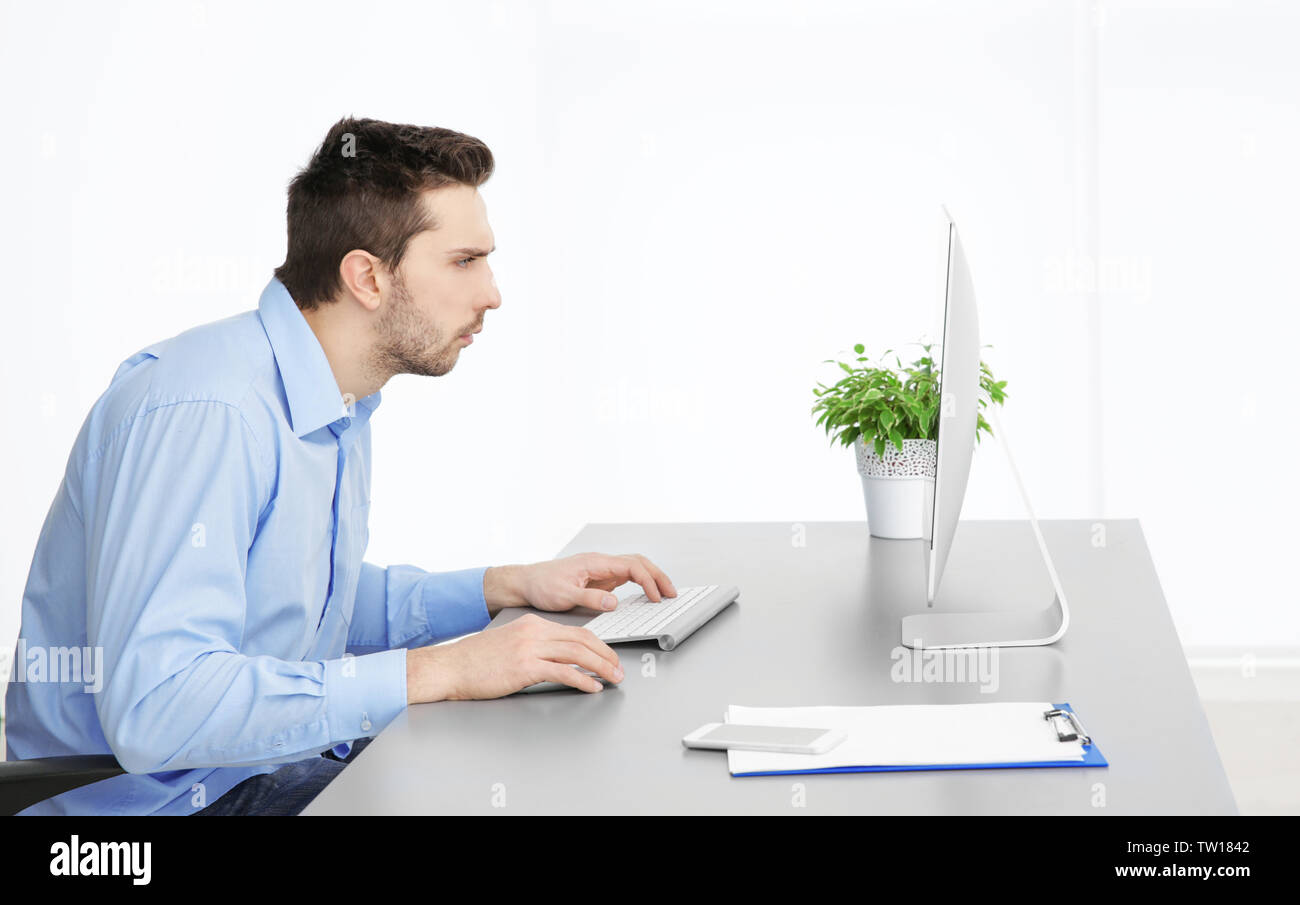 La possibilità di postura non corretta nozione. Uomo seduto al tavolo per ufficio Foto Stock