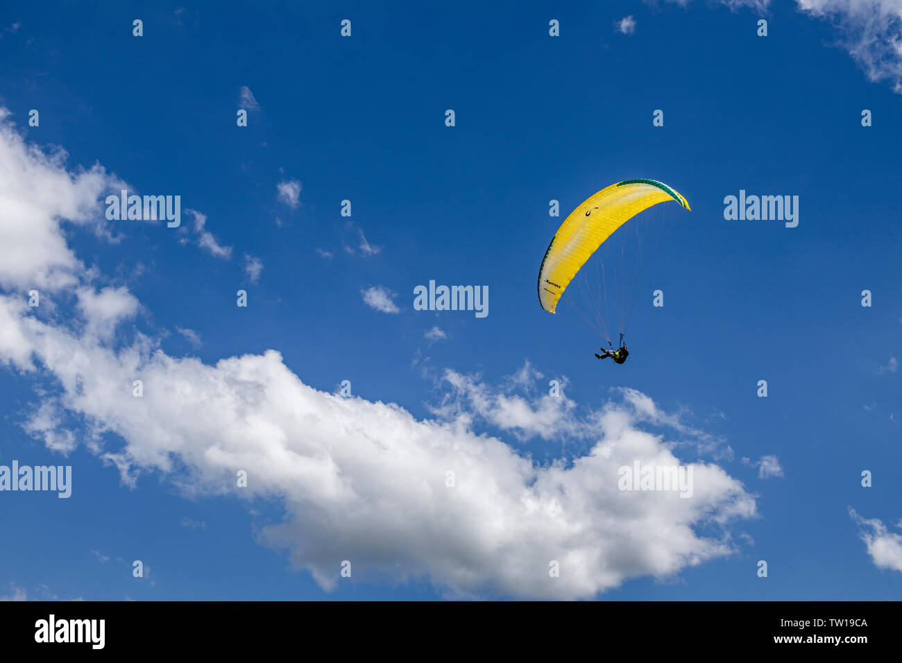 Oostduinkerke, Belgio - 19 Giugno 2019: Un parapendio è floatring in aria tra le nuvole wihte Foto Stock