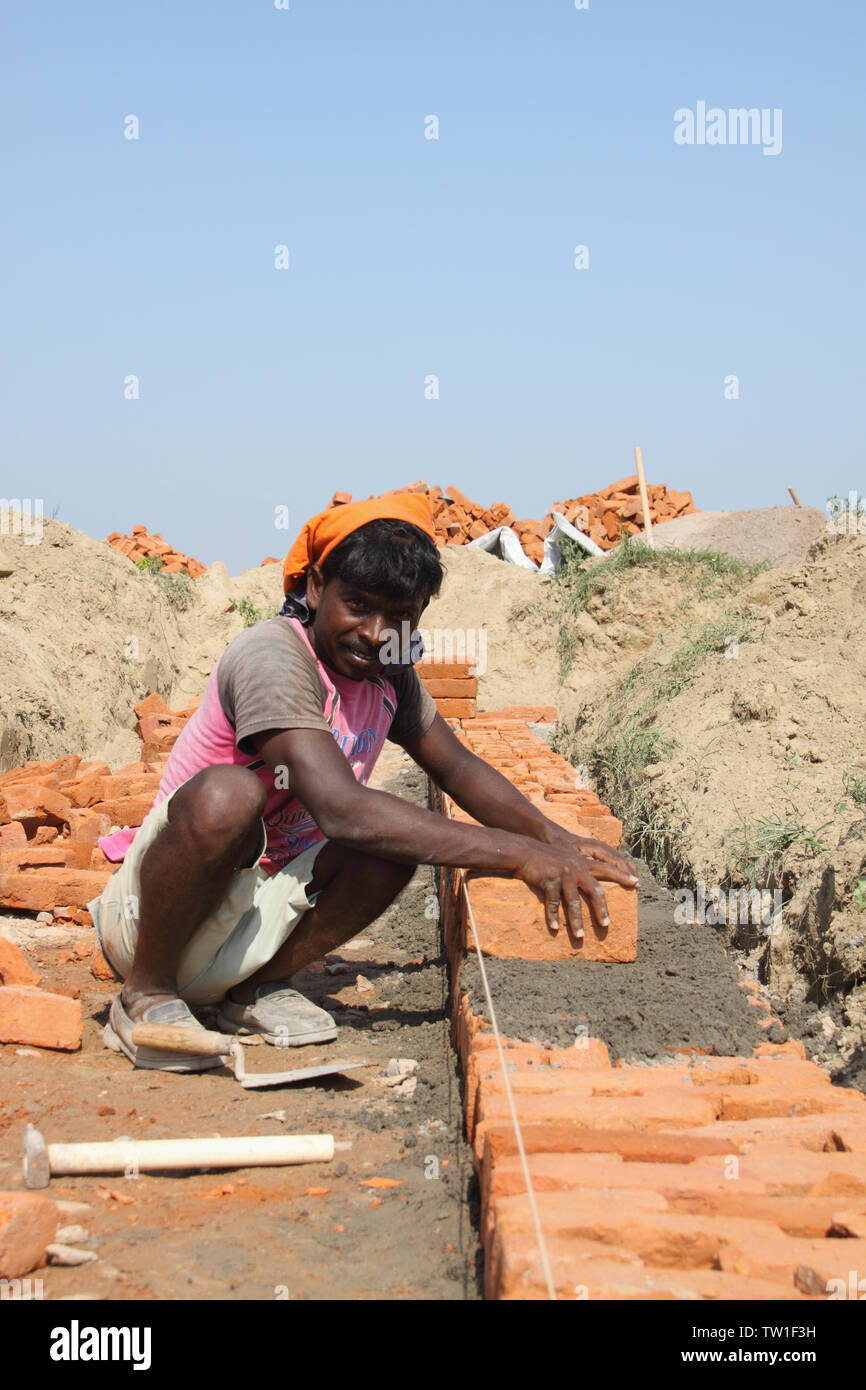 Mason che lavora in un cantiere, India Foto Stock