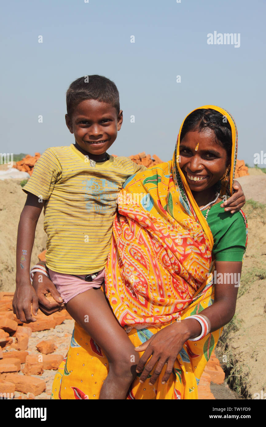 Donna che porta suo figlio in un cantiere, India Foto Stock