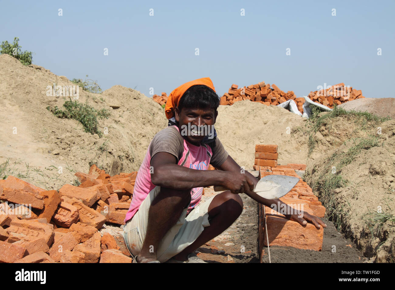 Mason che lavora in un cantiere, India Foto Stock