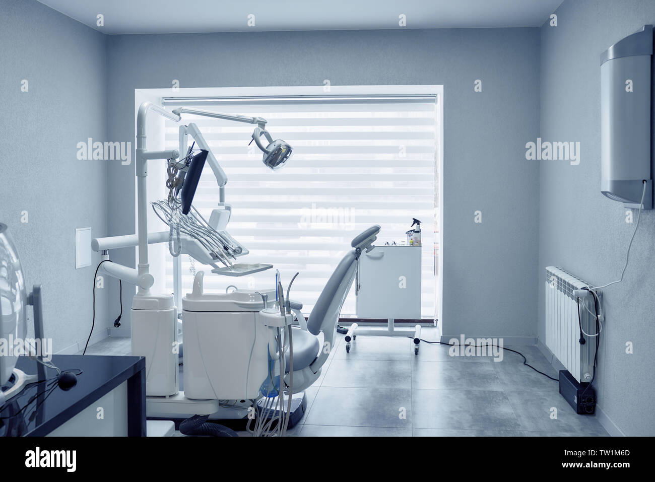 Vista dal lato del professional apparecchiature odontoiatriche e strumenti moderni in studio dentistico. Computer, dispositivi e sede per lo svolgimento delle procedure odontoiatriche in clinica. Concetto di stomatologia e odontoiatria. Foto Stock