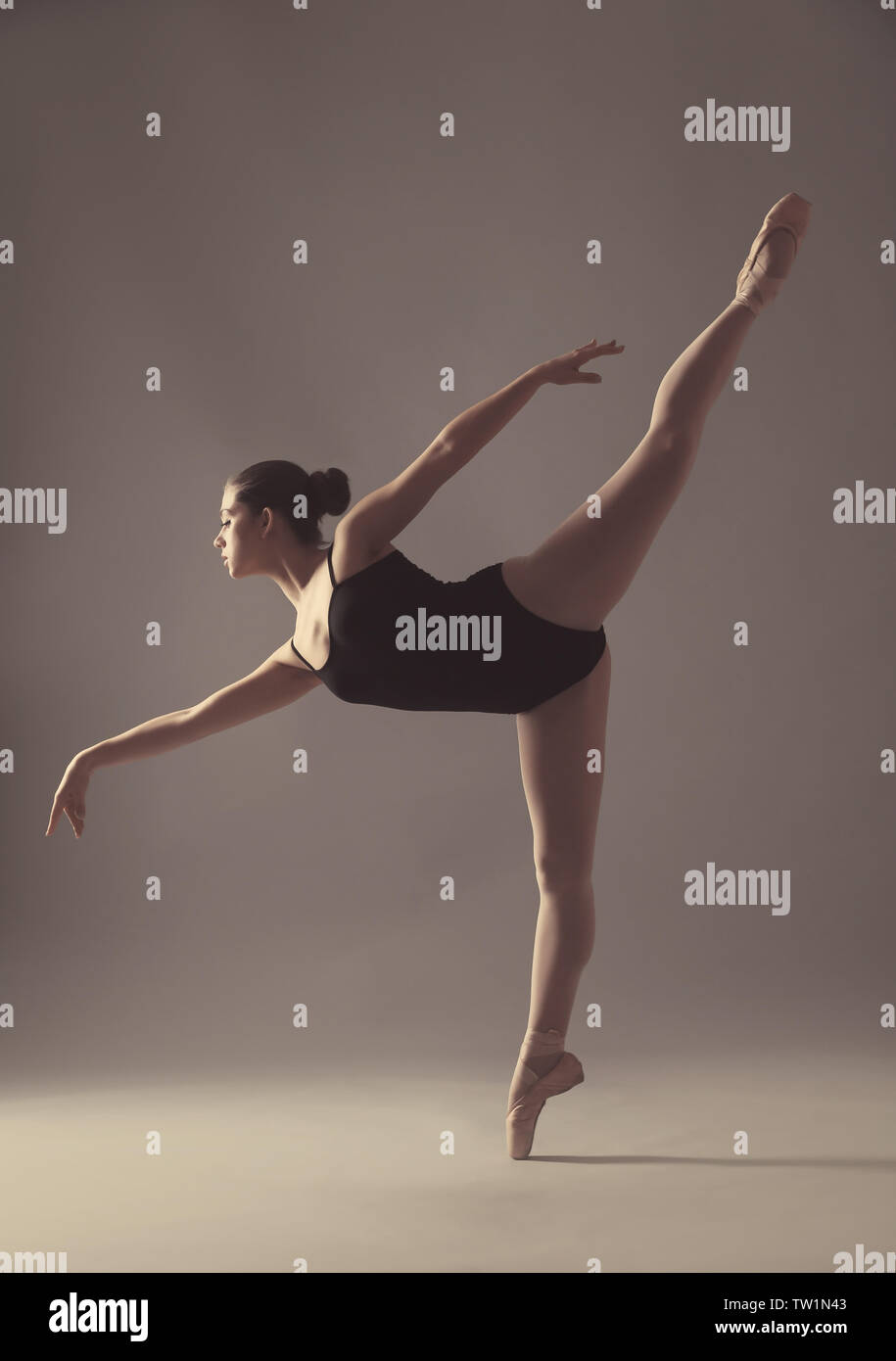 Giovane bella ballerina danza su sfondo chiaro Foto Stock