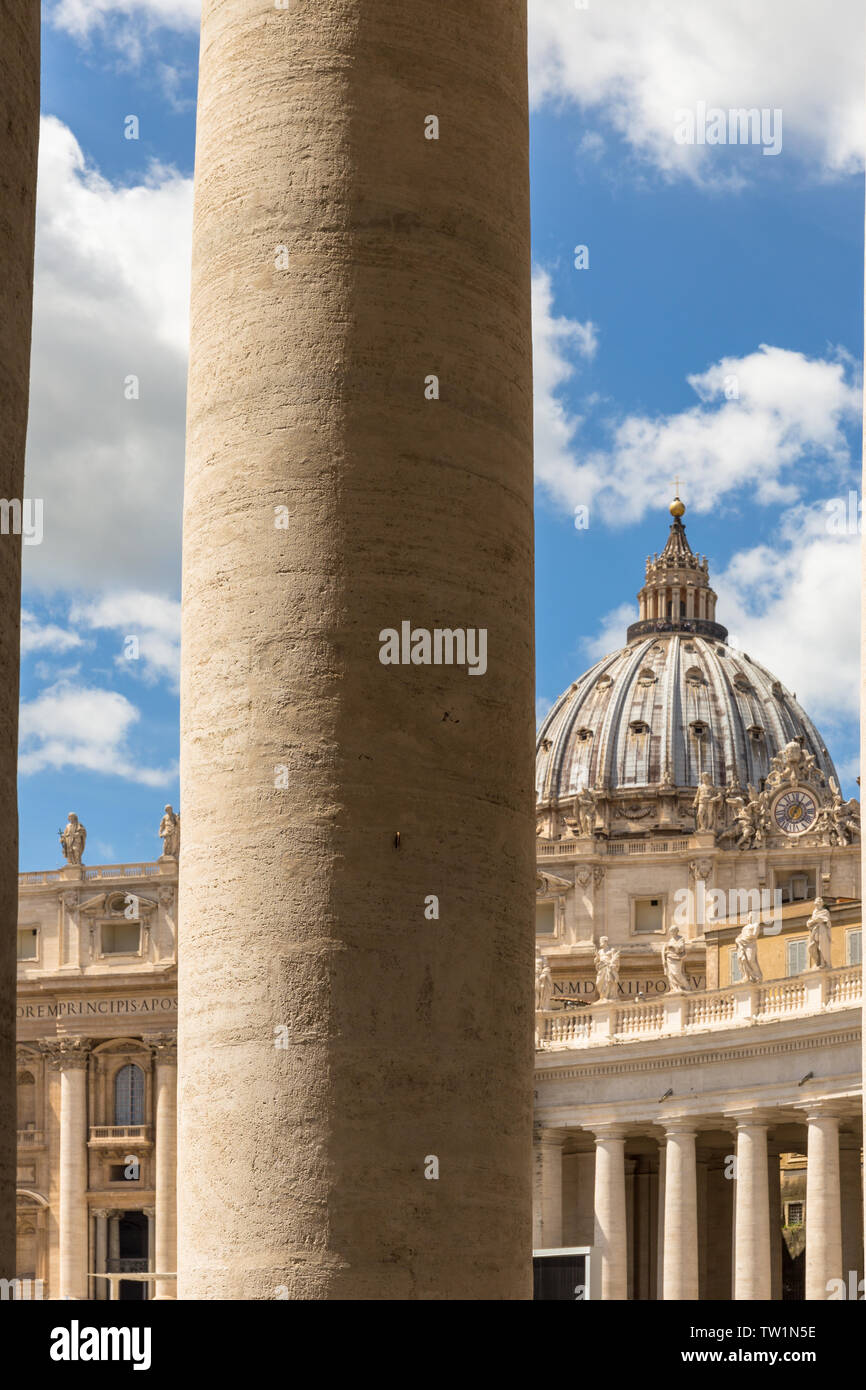 La cupola di San Pietro si vede attraverso il colonnato del Bernini in Piazza San Pietro e Città del Vaticano. Colonna stile dorico dettaglio. Foto Stock