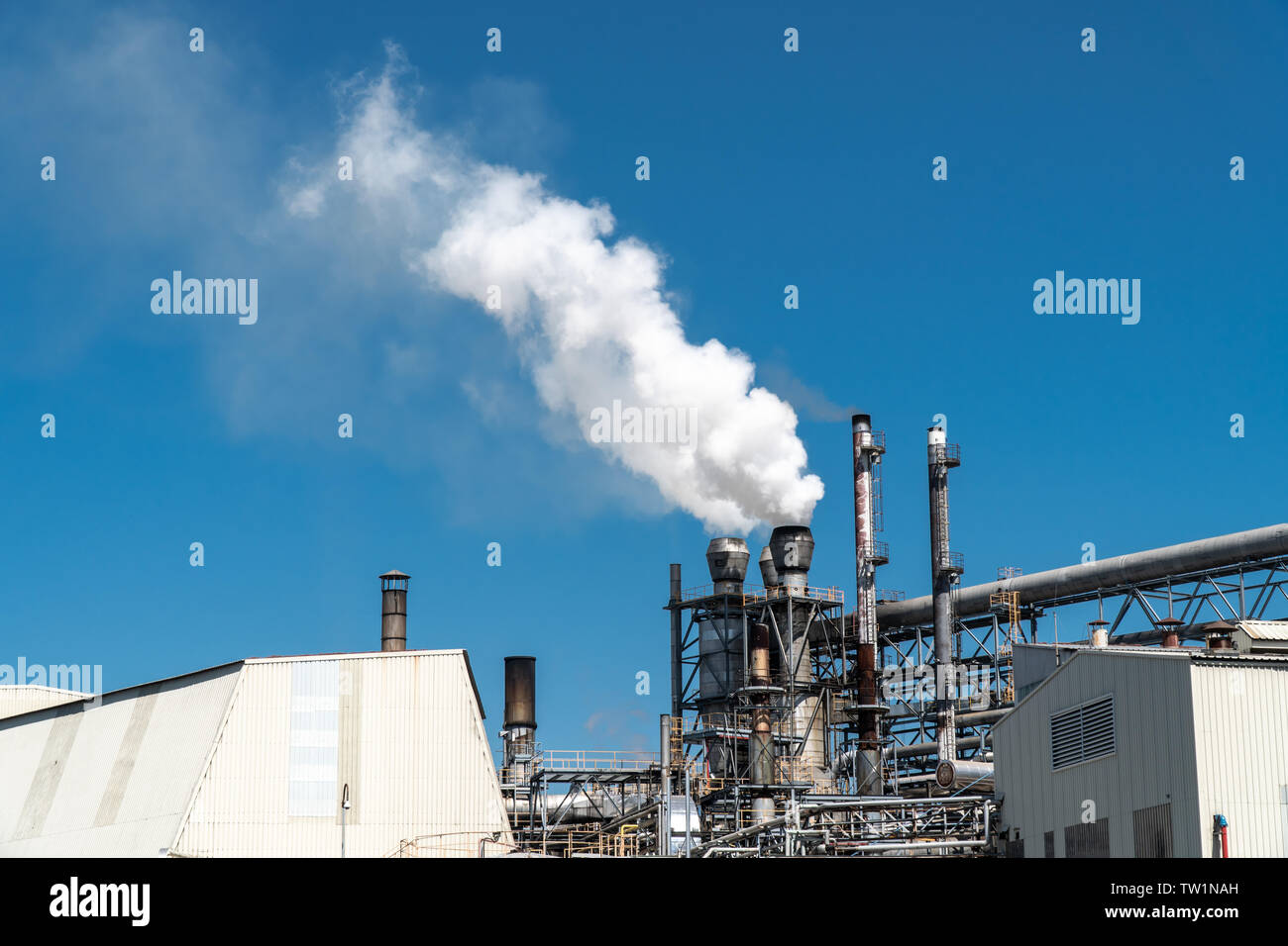 Emissione di fumo dalla fabbrica tubi sul cielo blu Foto Stock