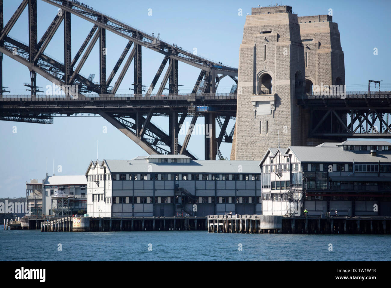 Vista in dettaglio dall'acqua di Sydney Harbour Bridge dotato di pontili storico di alloggiamento della Sydney Theatre Company di Sydney e il Sydney Dance Company Foto Stock