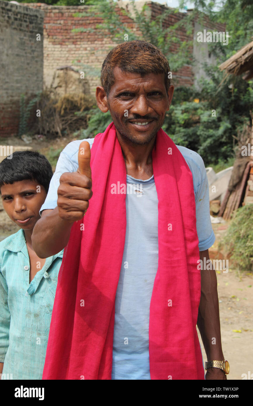 Ritratto di un villager che mostra pollici in su e sorridente, India Foto Stock