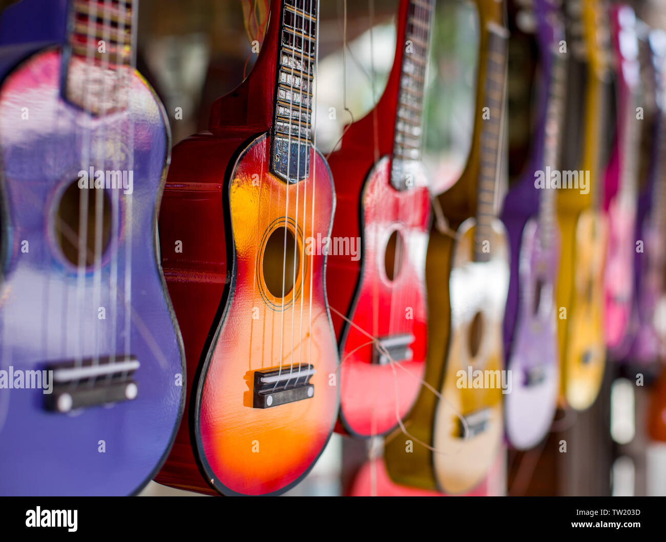 Multi-colore di chitarre. Poco chitarre di diversi colori. La foto è stata scattata sull'apertura. Una chitarra a fuoco il resto è sfocato. Foto Stock
