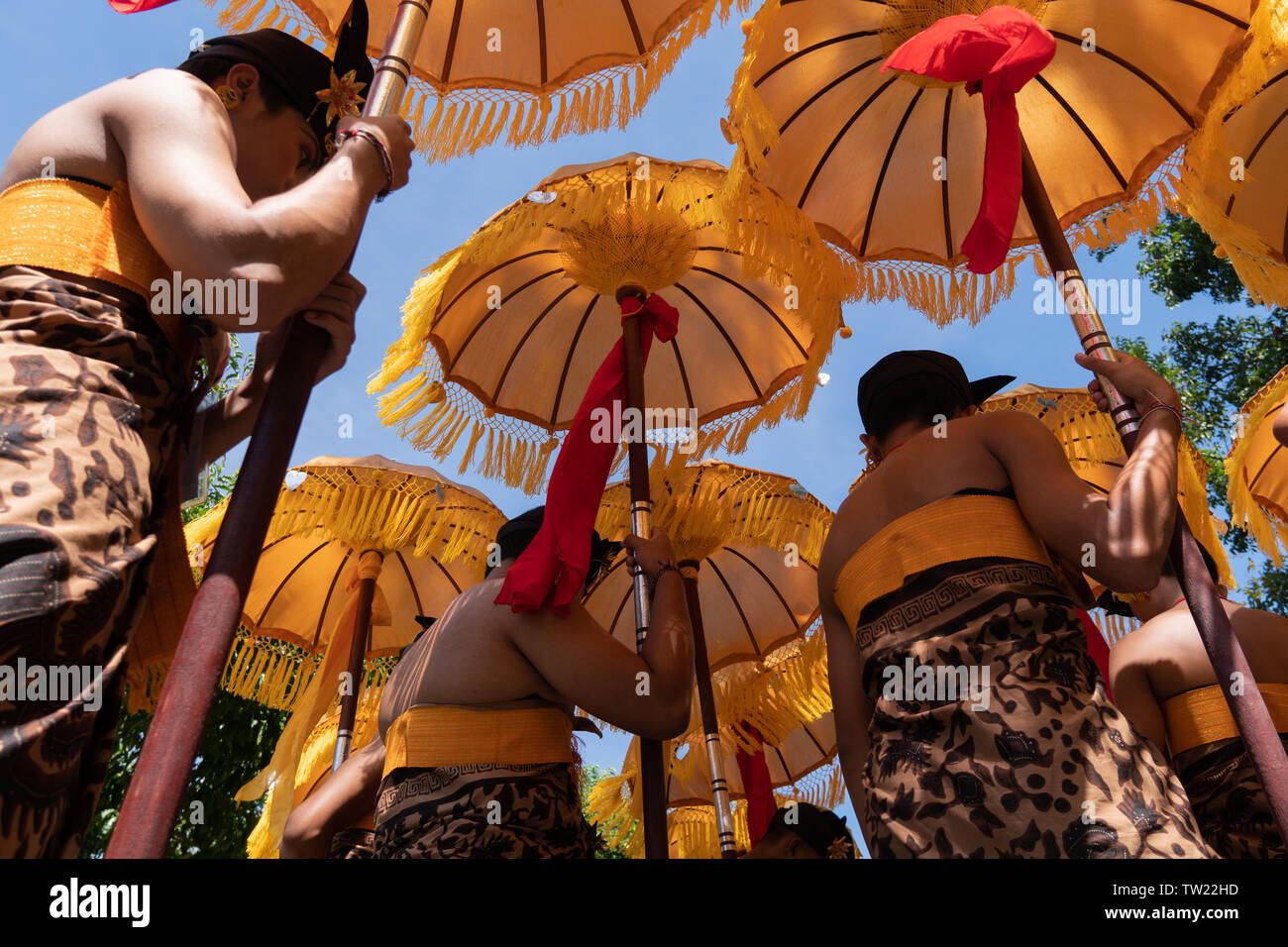 Gruppo di ballerini Balinesi in costumi etnici con tradizionale ombrelloni colorati sulla cerimonia Indù parade durante il festival tempio. Popolo Balinese cultu Foto Stock