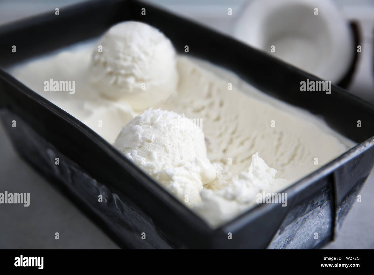 Contenitore nero con cocco fresco gelato, primo piano Foto Stock