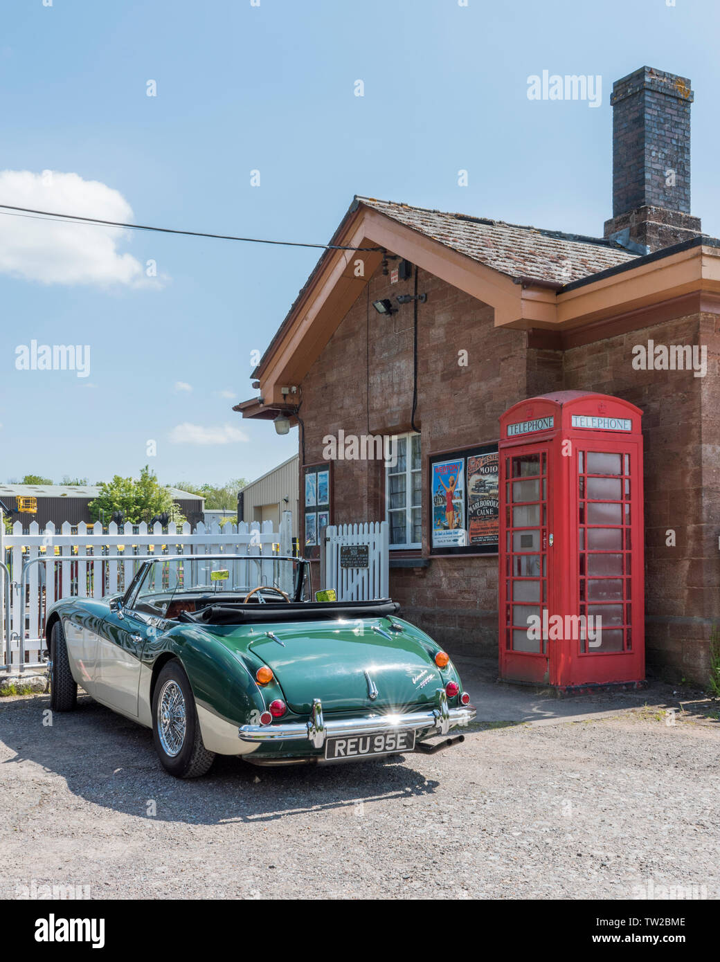 Austin Healy parcheggiata da un telefono rosso scatola a vescovi Lydeard stazione sul West Somerset Railway, Somerset, Inghilterra, Regno Unito Foto Stock