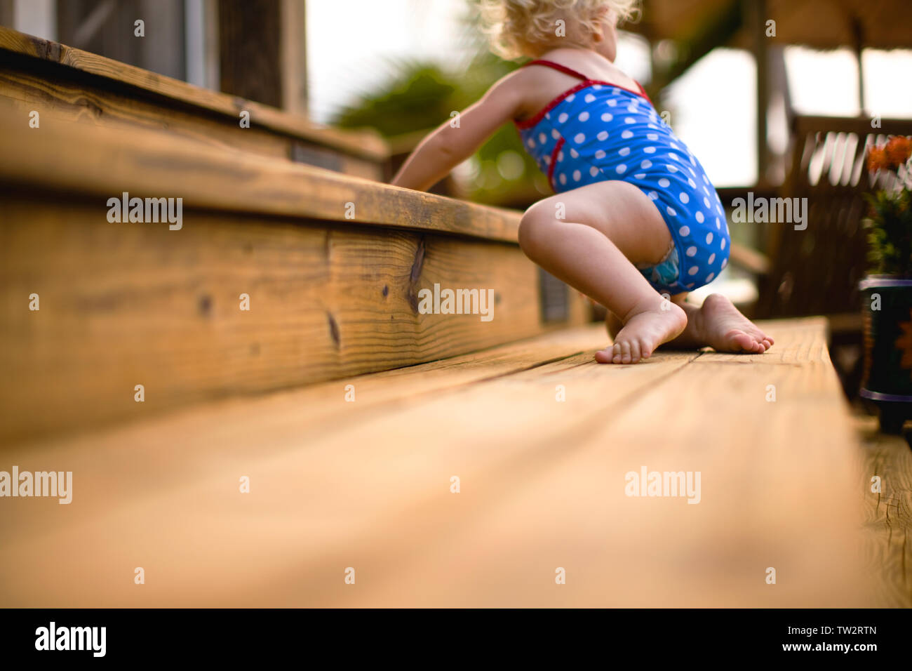 Baby strisciare sui gradini in legno. Foto Stock