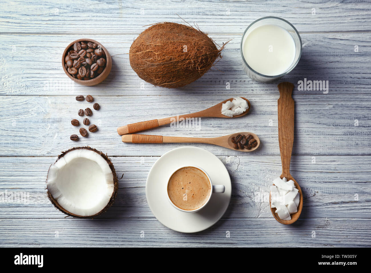 Cup con bevande e ingredienti per il caffè di noce di cocco sul tavolo di legno Foto Stock