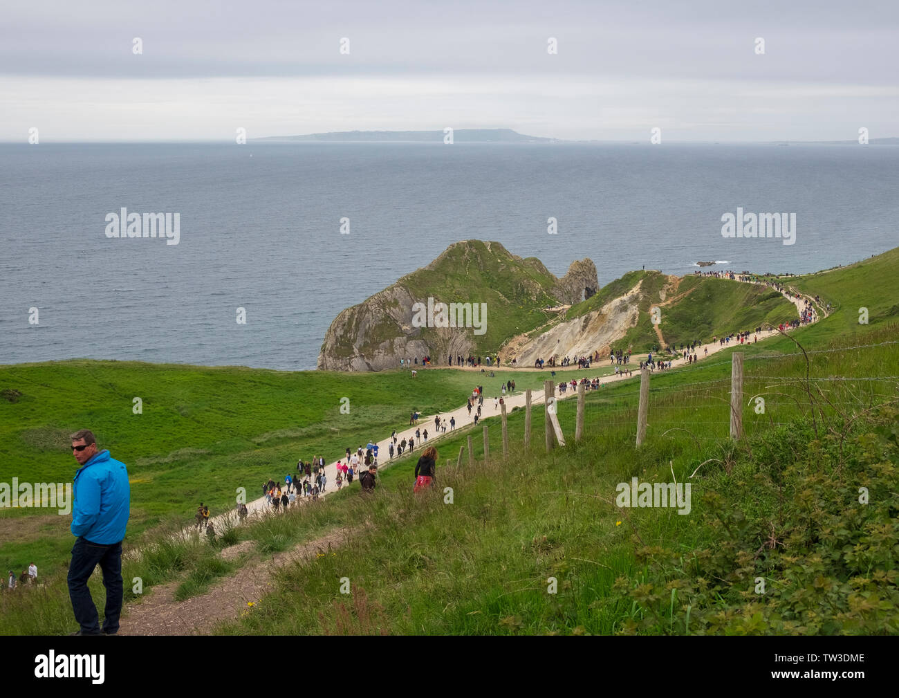 Un ottuso bank holiday domenica ma ancora folla sentiero verso l'iconica ubicazione di Durdle porta in Dorset Foto Stock