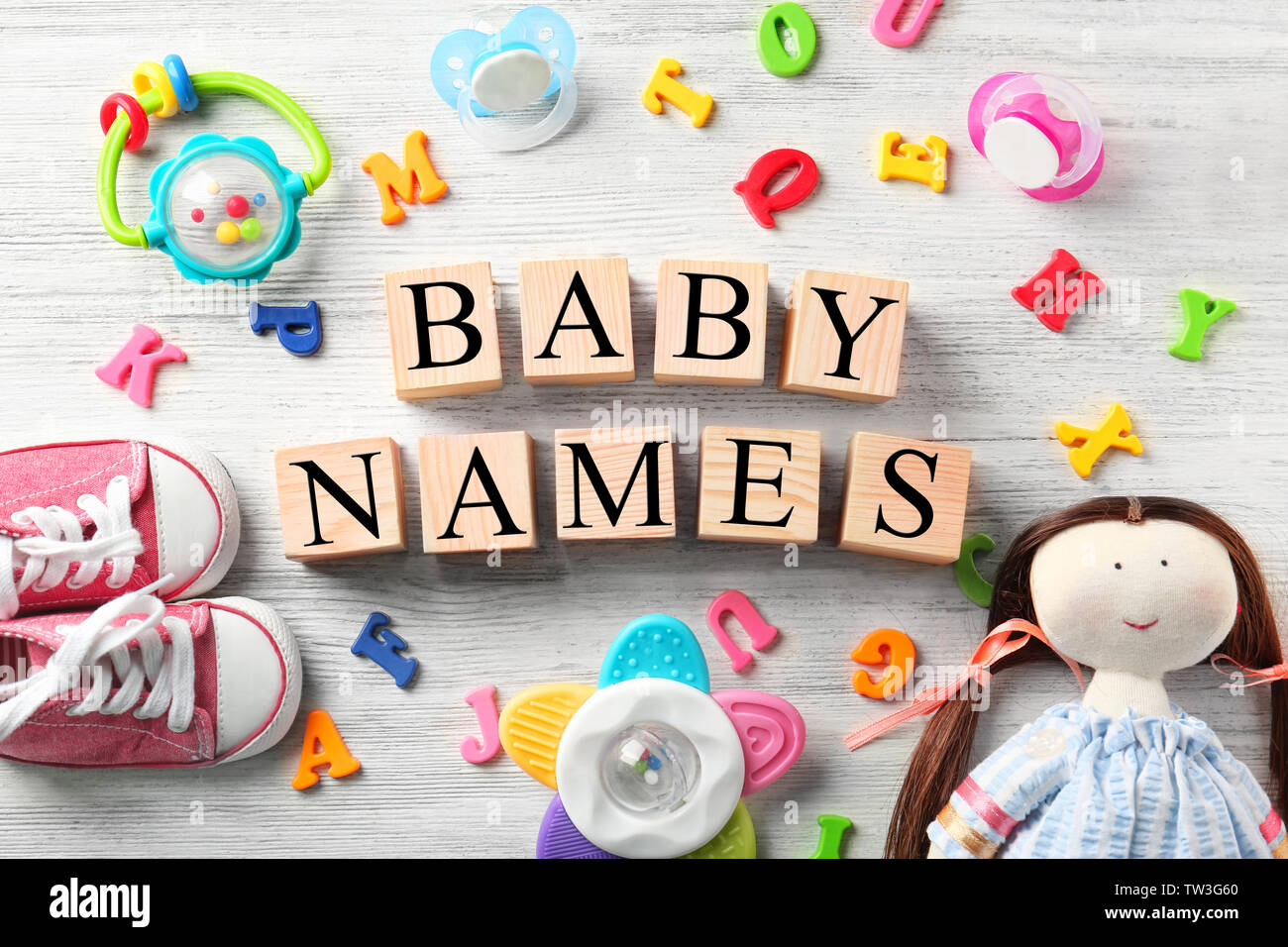 A cubetti con testo Nomi per bebè, giocattoli, succhietti, lettere di  plastica e scarpe su sfondo di legno Foto stock - Alamy