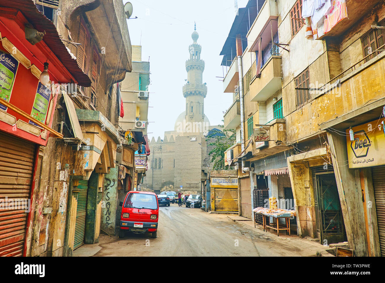 Il Cairo, Egitto - 22 dicembre 2017: a piedi la meschina El Darb El Ahmar street con una vista sulla storica Amir Al-Maridani moschea in luce winter haze, su Dec Foto Stock