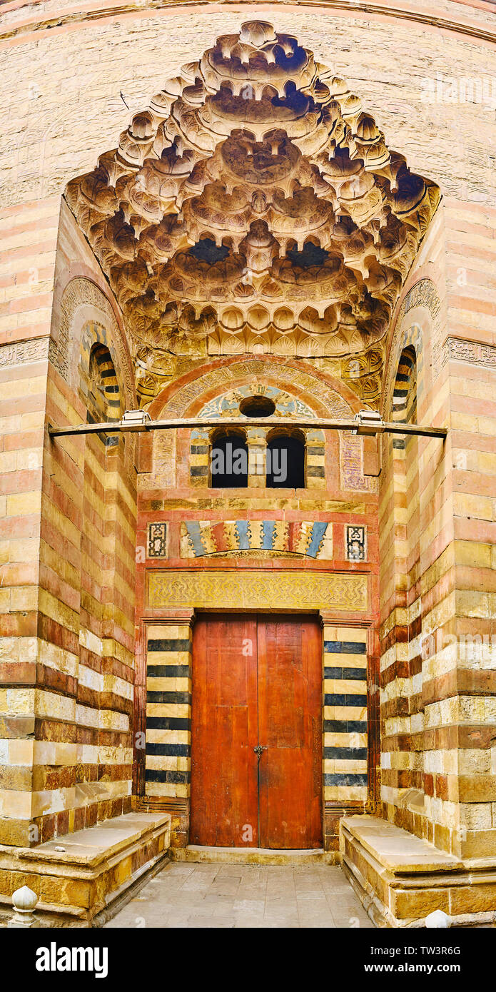 Il cancello di ingresso di Umm Al-Sultan Shaban moschea con belle muqarnas (honeycomb) decorazione e stile Ablaq (con striping) pareti di bianco e pietra rossa, ISL Foto Stock