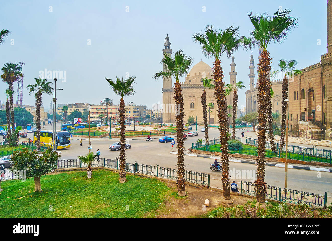 Il Cairo, Egitto - 21 dicembre 2017: la vista su occupato Salah El-Deen quadrato con il sultano Hassan e Al-Rifa io moschee attraverso gli alberi di palma, il 2 dicembre Foto Stock