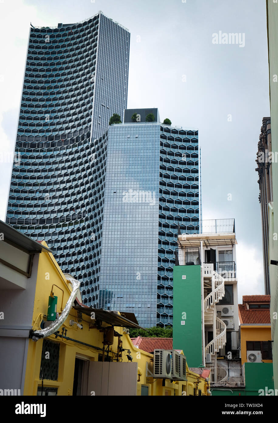 Duo moderne torri di Singapore che mostra il design di contrasto che si affacciano sul piccolo residenziale case tradizionali in bugis haji area di corsia Foto Stock