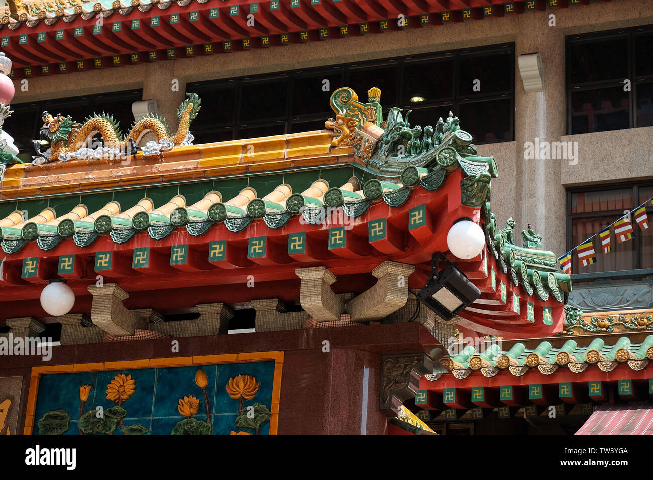 Kwan Im Thong Hood Cho tempio in Singapore, close up Sauwastika buddista di decorazione su tegole del tetto. Inoltre conoscere come Swastika a seconda del design. Foto Stock