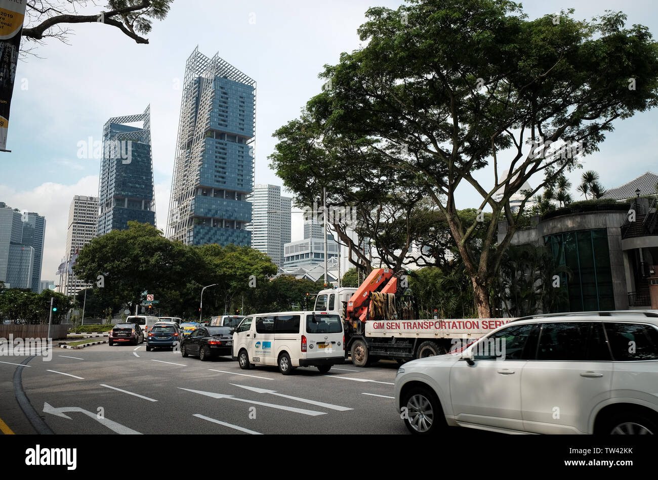 Una vista su strada di faggio Singapore Mostra traffico e grattacieli di South Beach Towers circondato da alberi. Foto Stock