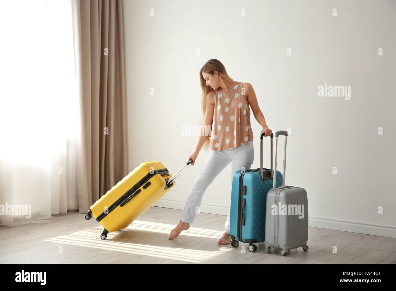 Giovane donna con le valigie in camera. Bagagli concetto sovrappeso Foto Stock