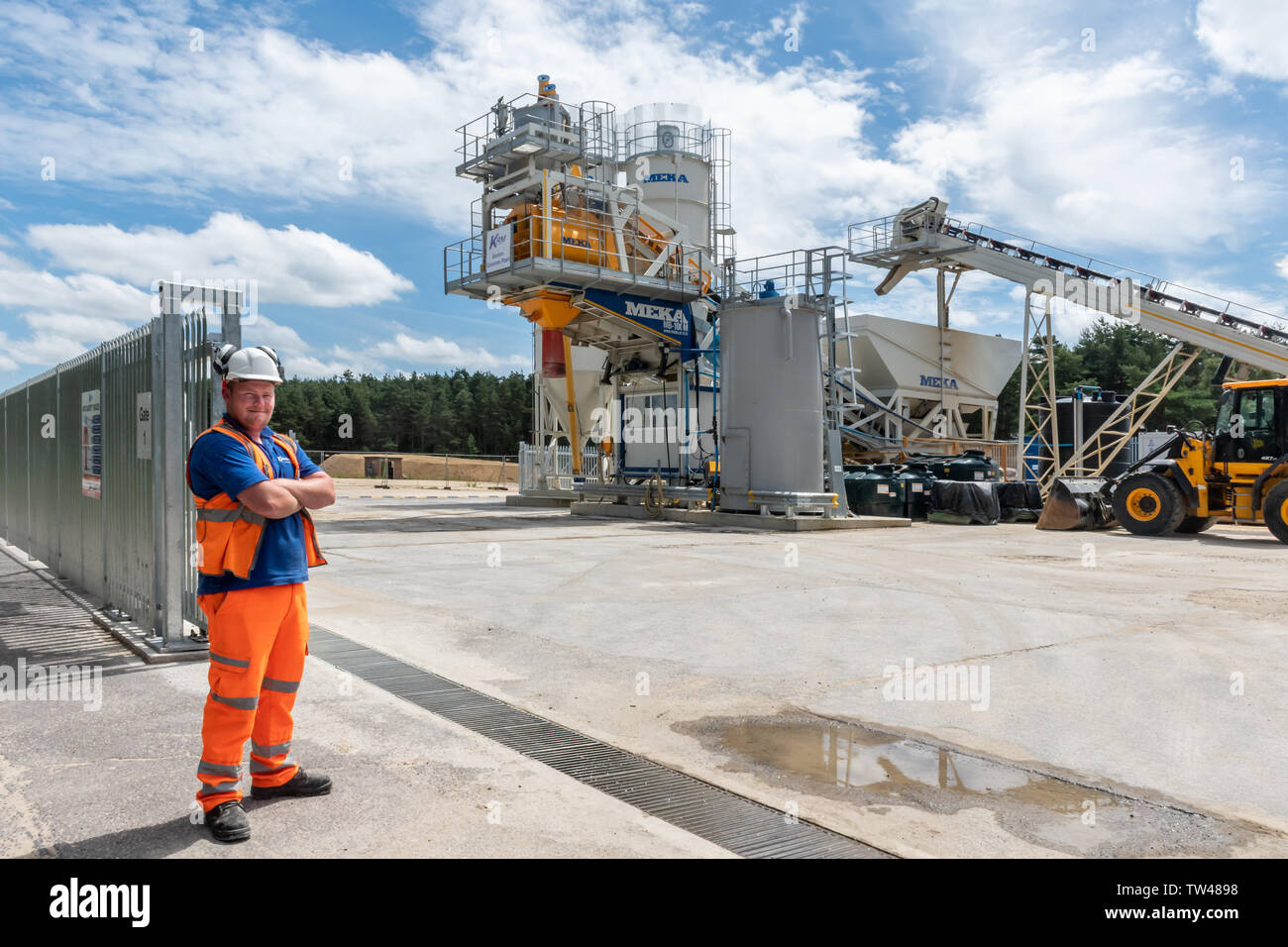 Workman in alta visibilità abbigliamento in piedi da Meka Ready Mix Concrete la dosatura di impianto per la produzione di calcestruzzo per l'edilizia REGNO UNITO Foto Stock