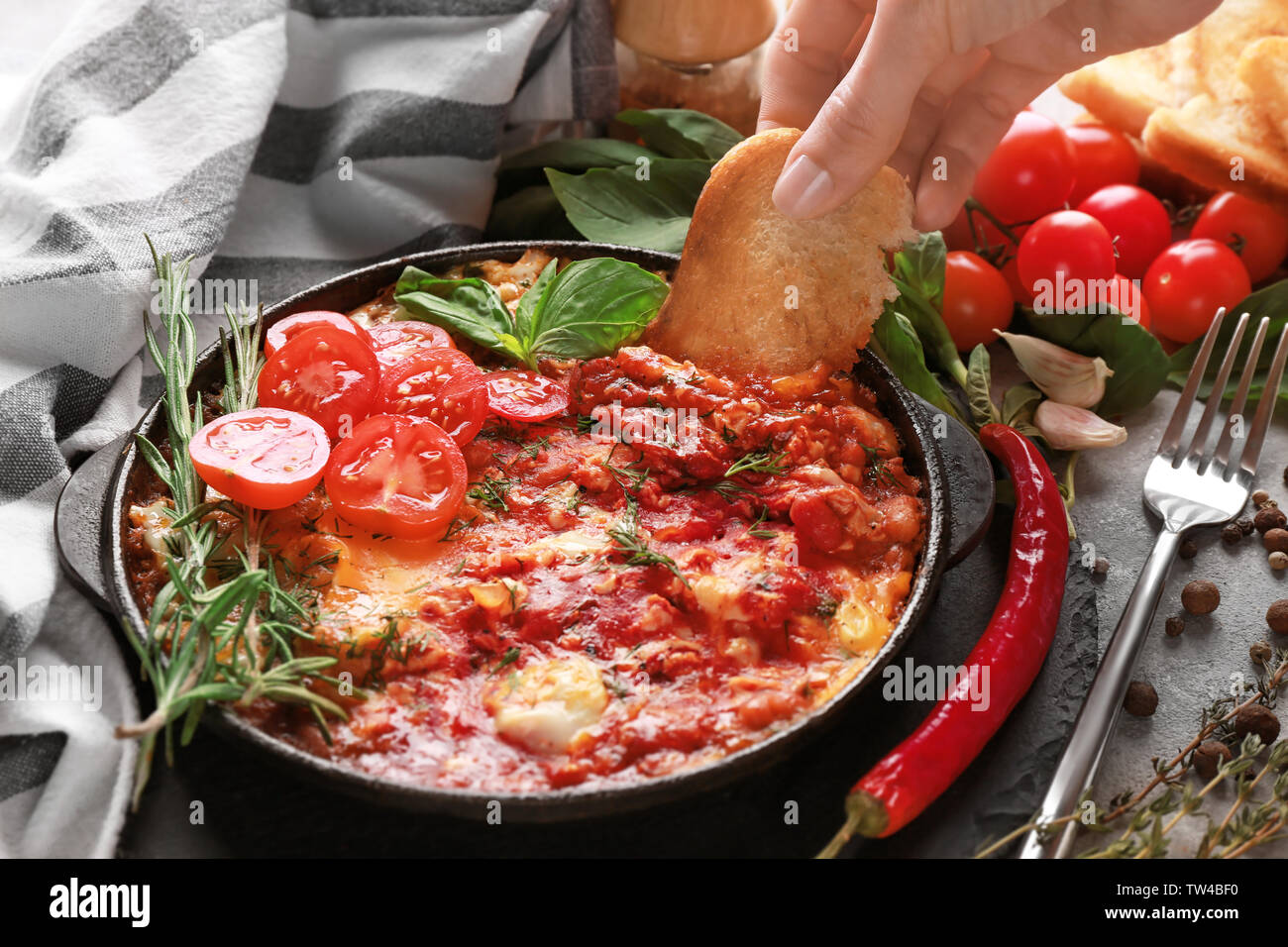 Donna intingere il pane nelle uova in purgatorio sul tavolo Foto Stock