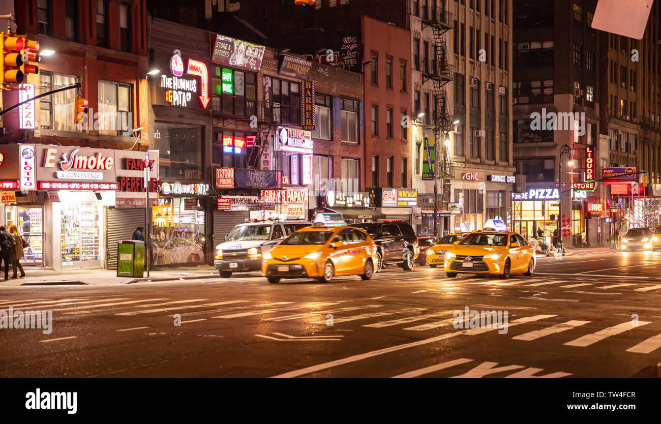 Stati Uniti d'America, New York Manhattan. Il 2 maggio 2019. Strade di notte. Edifici illuminati e colorati di luci al neon, auto e taxi, gente che cammina Foto Stock