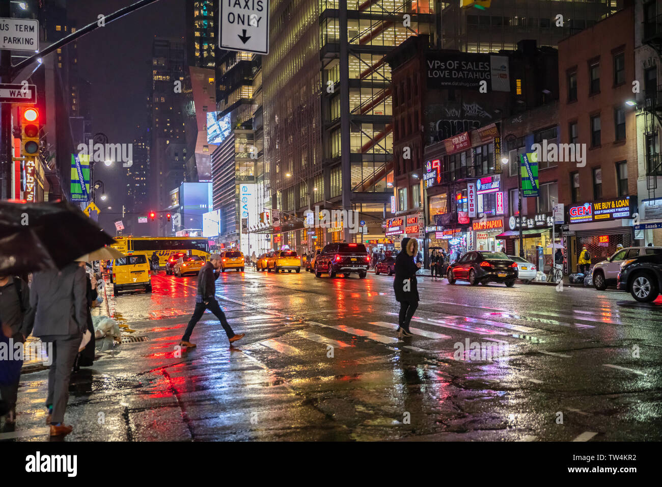 Stati Uniti d'America, New York Manhattan. Il 3 maggio 2019. Le strade di Broadway Una notte piovosa. Edifici illuminati e colorati di luci al neon, taxi, auto e persone a piedi Foto Stock