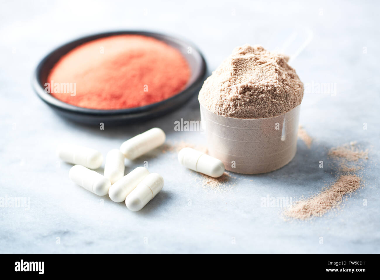 Scoop di proteina del siero di latte, beta-alanina capsule e creatina in polvere. Foto Stock