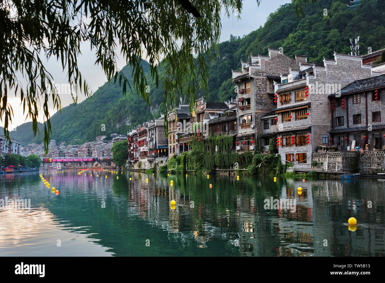Case tradizionali lungo il fiume Wuyang con riflesso nell'acqua, Zhenyuan, Guizhou, Cina Foto Stock