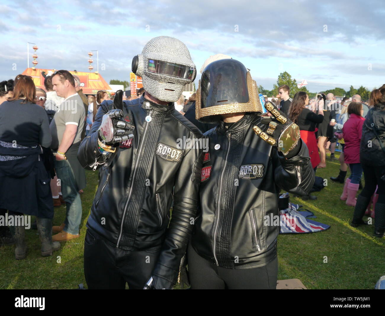 Newport, Isola di Wight. Il 16 giugno 2019. Isle of Wight Festival - Robot umani duo con il biker caschi in mostra il loro abbigliamento costumi nouveau. Foto Stock