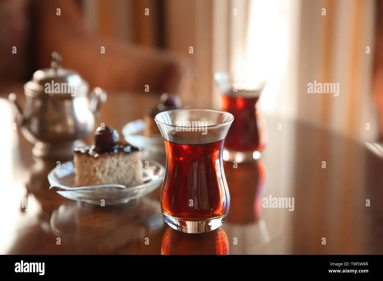 Tè turco in vetro tradizionale con dessert sulla tavola Foto Stock