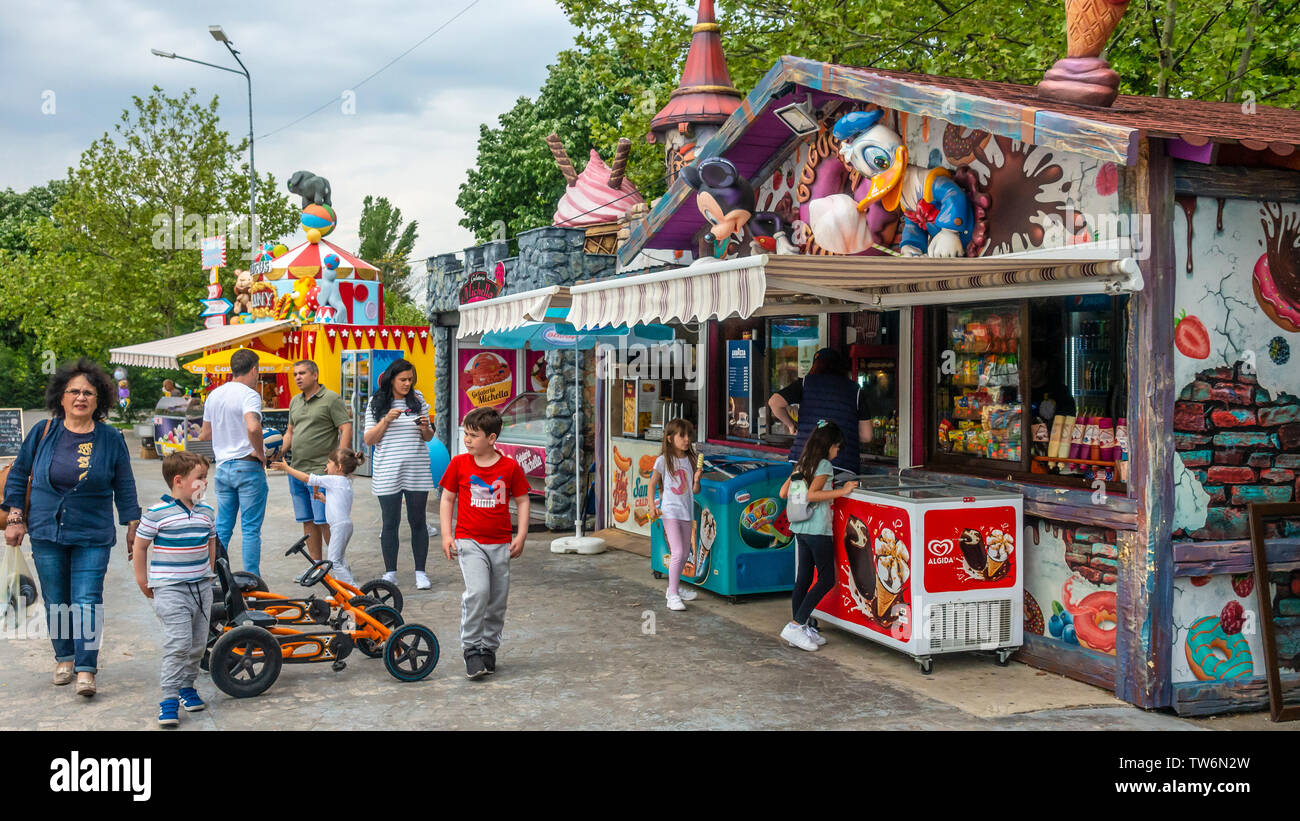 Adulti e bambini in uno spuntino area di stallo di Lumea Parcul Copiilor, il mondo bambini Park, nel centro di Bucarest, Romania. Foto Stock