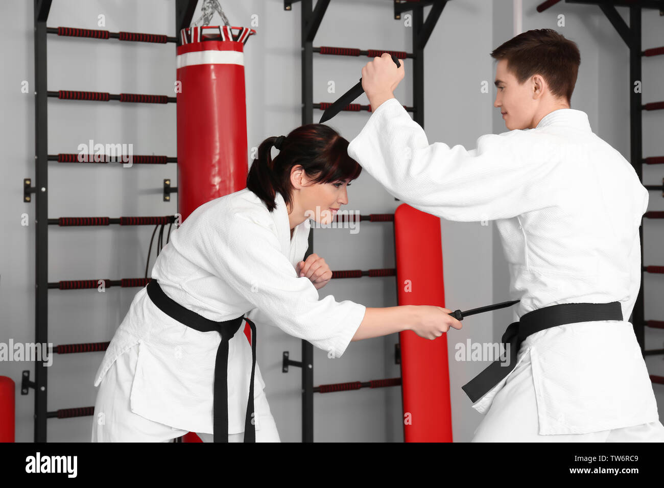 Giovane uomo e donna a praticare arti marziali nel dojo Foto Stock
