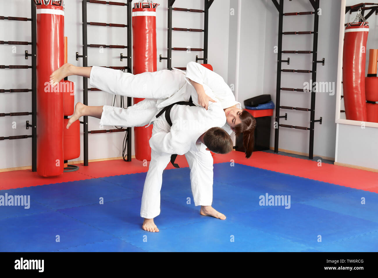 Giovane uomo e donna a praticare arti marziali nel dojo Foto Stock
