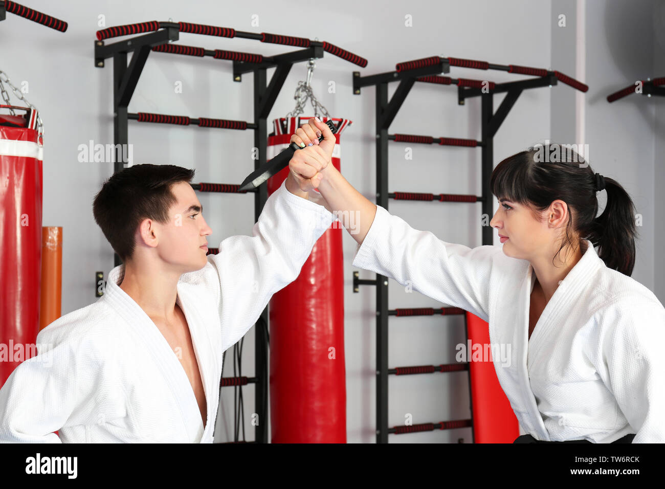 Giovane uomo e donna a praticare arti marziali nel dojo Foto Stock