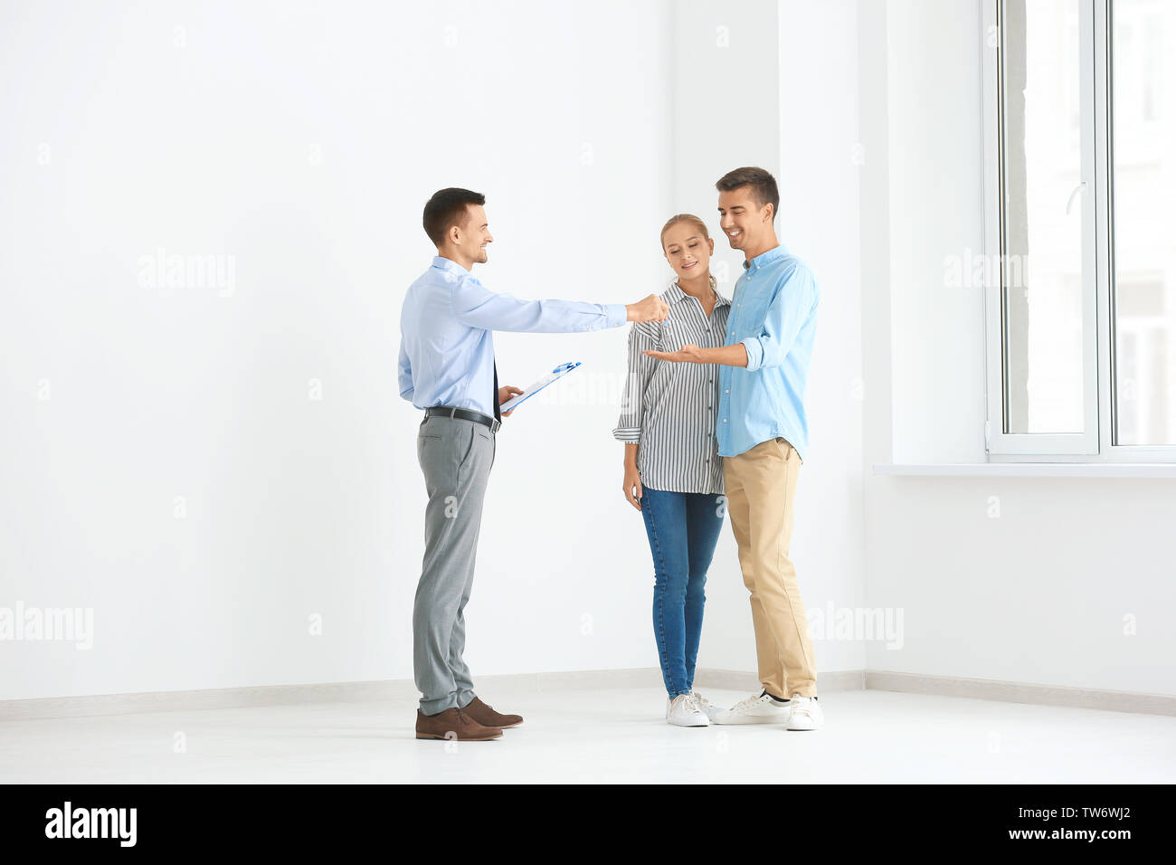 Agente immobiliare dando ai clienti chiave dal nuovo flat Foto Stock