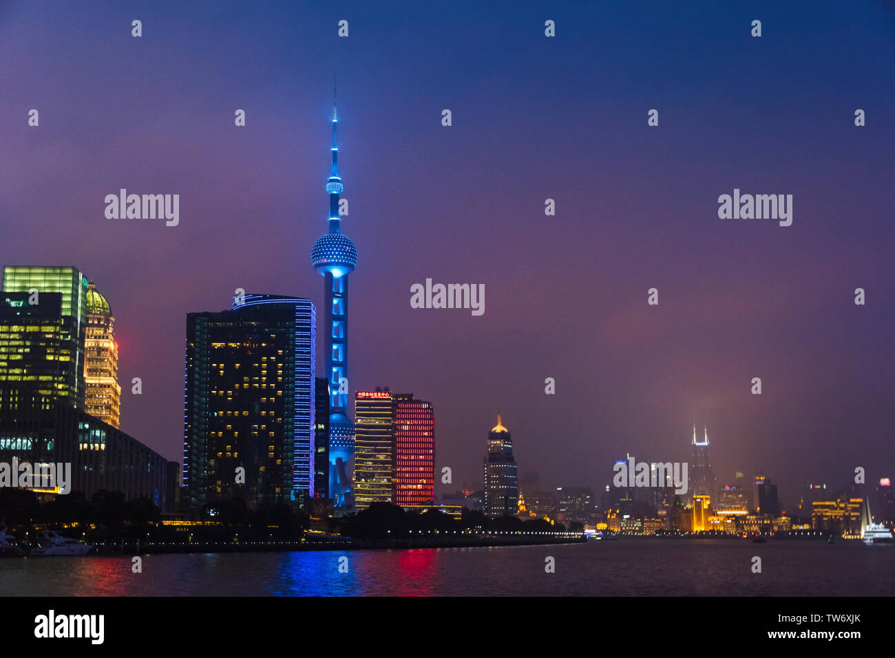 Vista notturna della Oriental Pearl TV Tower e alta sorge dal fiume Huangpu, Pudong, Shanghai, Cina Foto Stock