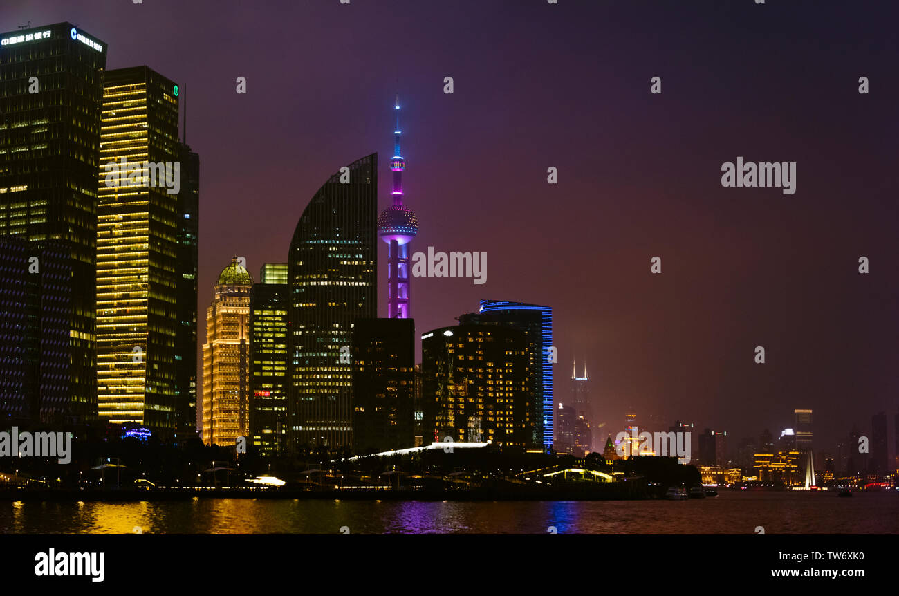 Vista notturna della Oriental Pearl TV Tower e alta sorge dal fiume Huangpu, Pudong, Shanghai, Cina Foto Stock