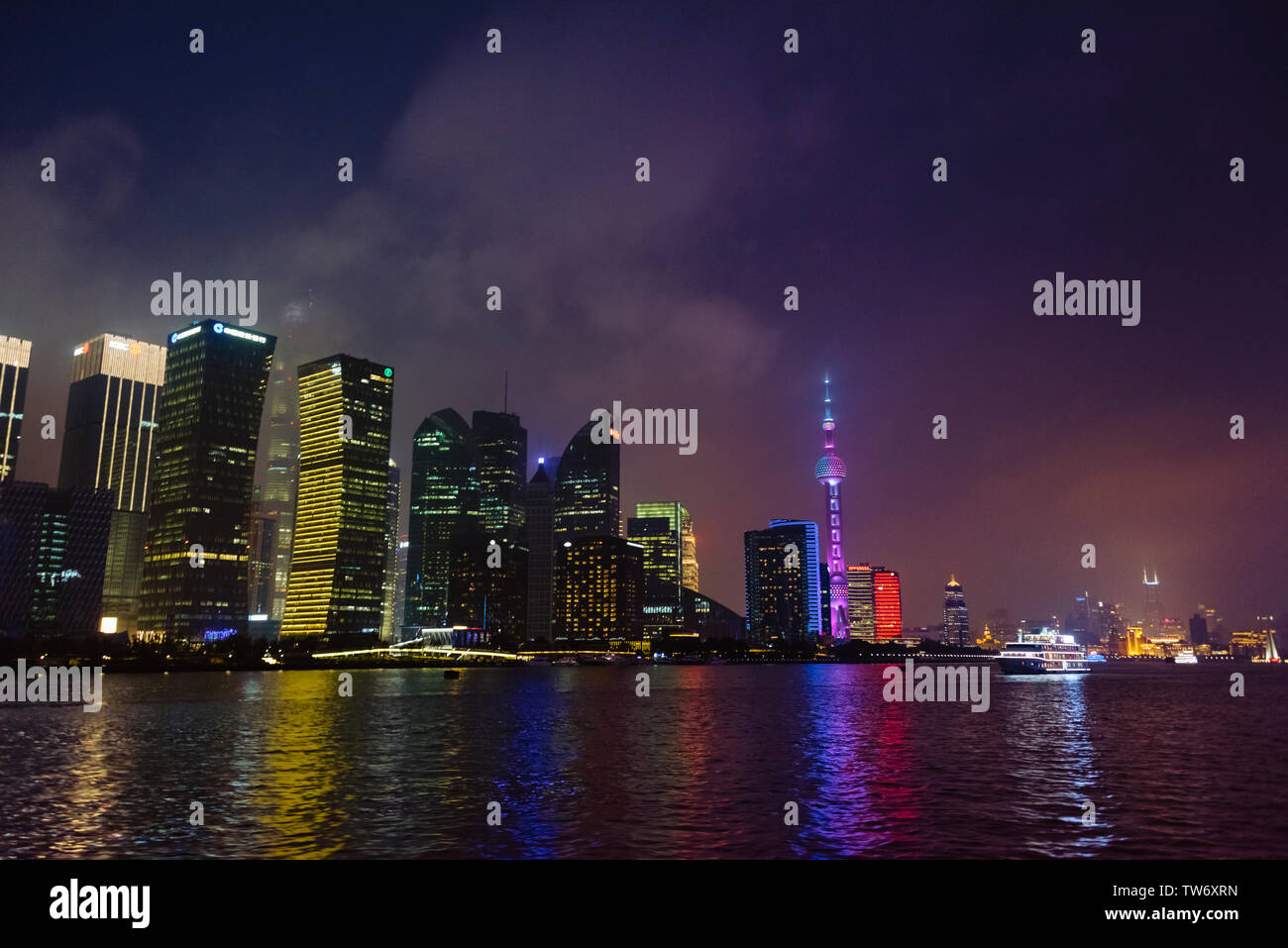 Vista notturna della Oriental Pearl TV Tower e alta sorge dal fiume Huangpu, Pudong, Shanghai, Cina Foto Stock