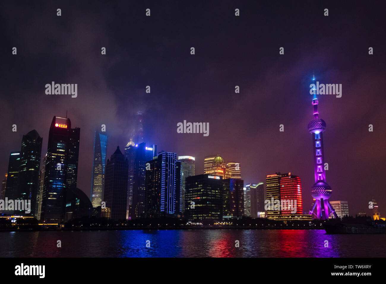 Vista notturna della Oriental Pearl TV Tower e alta sorge dal fiume Huangpu, Pudong, Shanghai, Cina Foto Stock