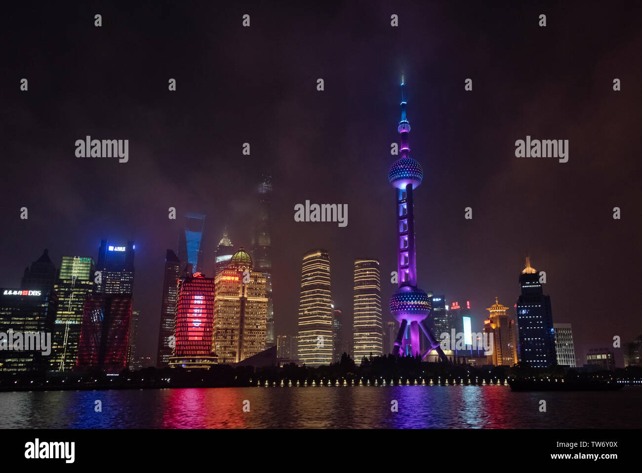 Vista notturna della Oriental Pearl TV Tower e alta sorge dal fiume Huangpu, Pudong, Shanghai, Cina Foto Stock