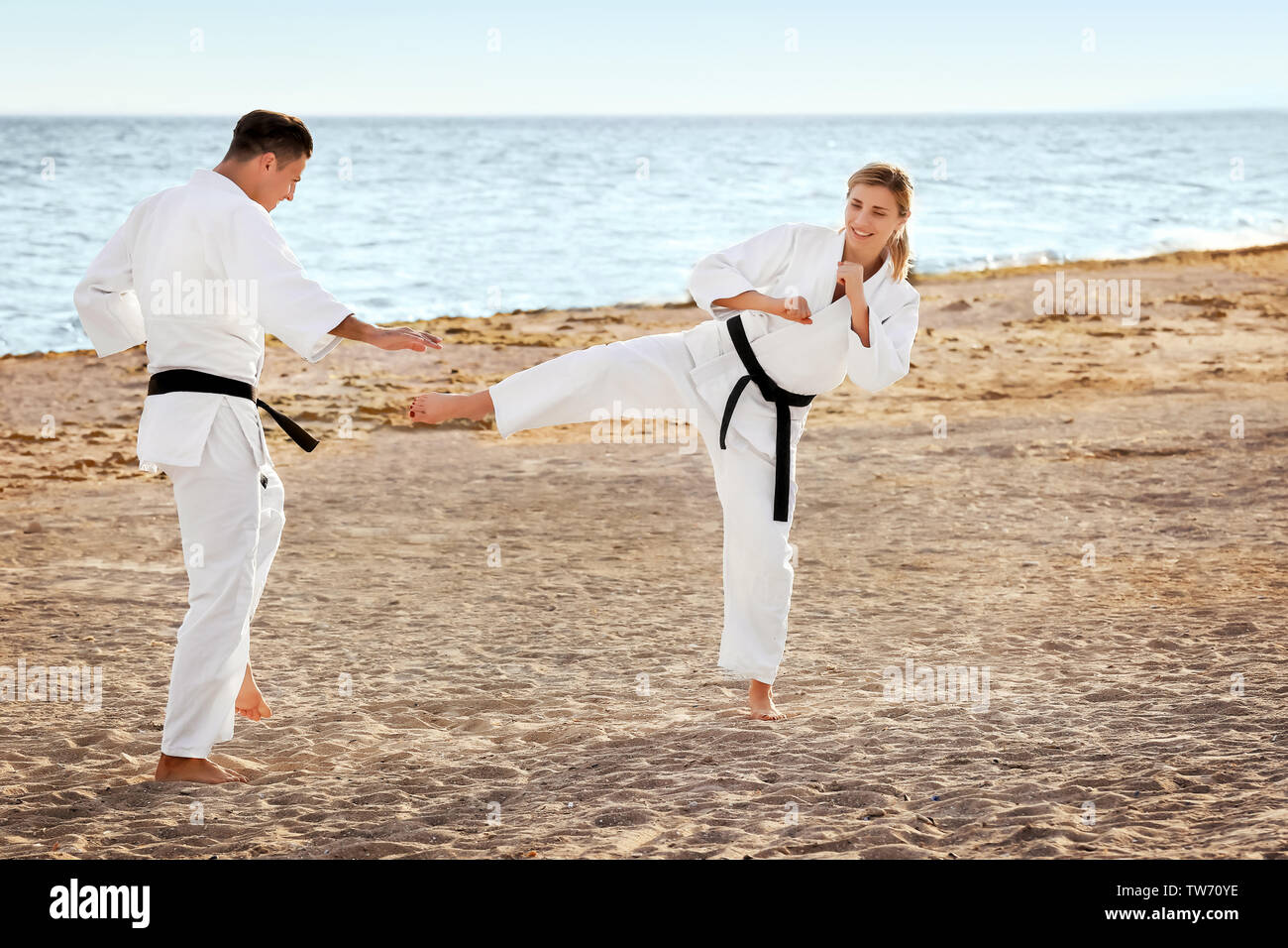 Giovane uomo e donna a praticare il karate all'aperto Foto Stock