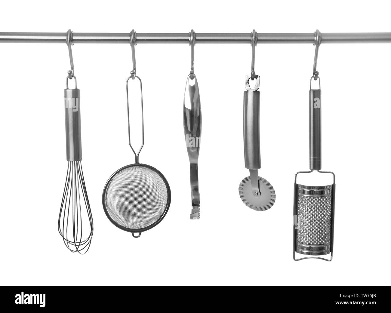 Set di utensili da cucina appeso sul rack, isolato su bianco Foto Stock