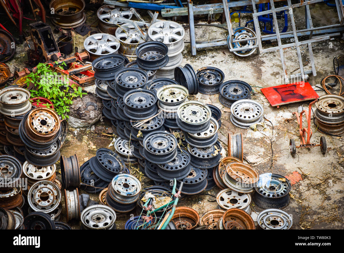heap of old rusty metal wheel rims in the car dum wheel vehicle waste Foto Stock