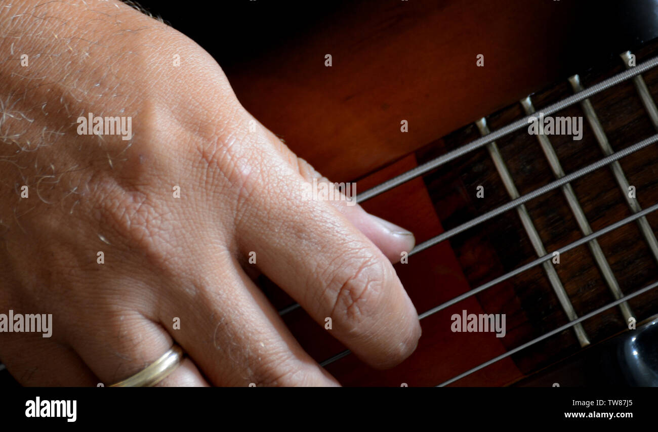 4 corde vitange basso elettrico chitarra con le mani la riproduzione e la prospettiva diversa Foto Stock