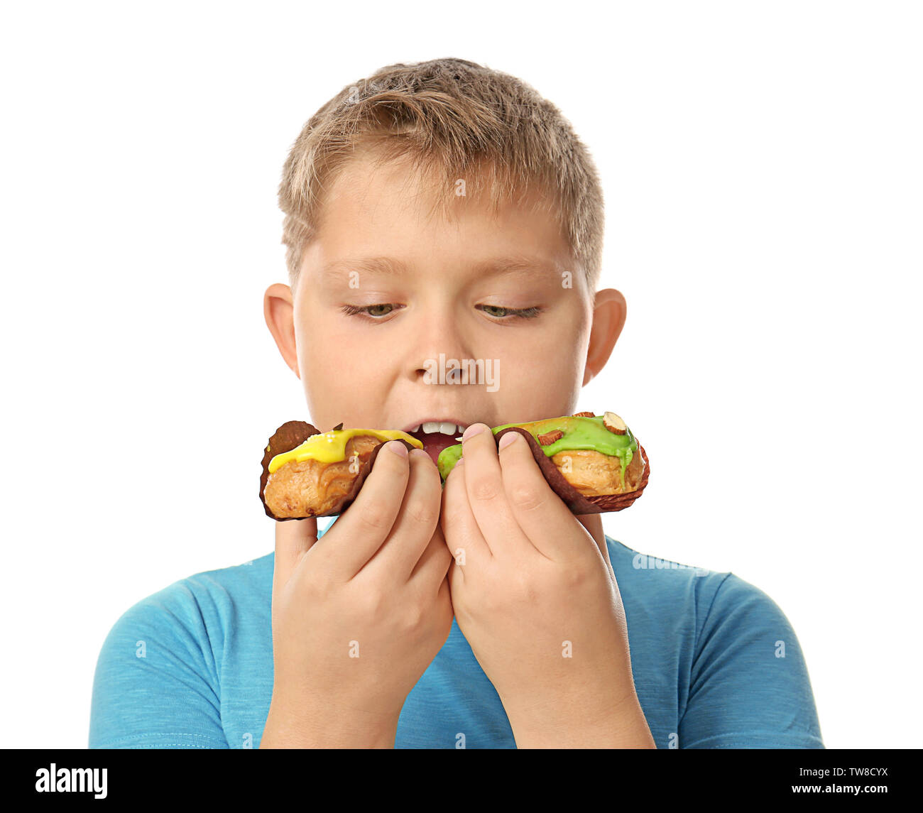 Ragazzo in sovrappeso mangiano eclairs su sfondo bianco Foto Stock